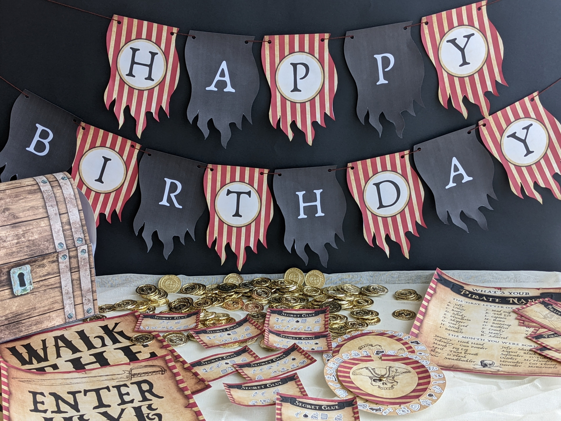 Pirate-themed birthday party decorations with 'Happy Birthday' banner, gold coins, and wooden barrel.