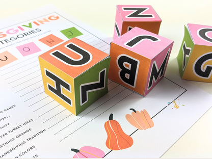 Four game dice with letters on it, laid on top of a thanksgiving themed scattegories game board.